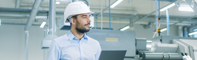 Chief Engineer in the Hard Hat Walks Through Light Modern Factory While Holding Laptop. Successful, Handsome Man in Modern Industrial Environment. custom & Flexible Ordering by GD Rectifiers. Website terms by GD Rectifiers.