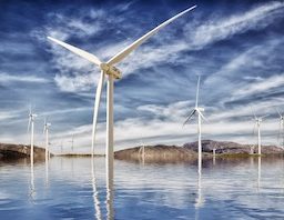 Wind energy, wind turbine farm with a bright blue background.