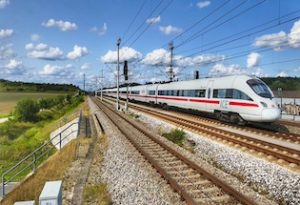 Rail image, train on a track, sun shining.